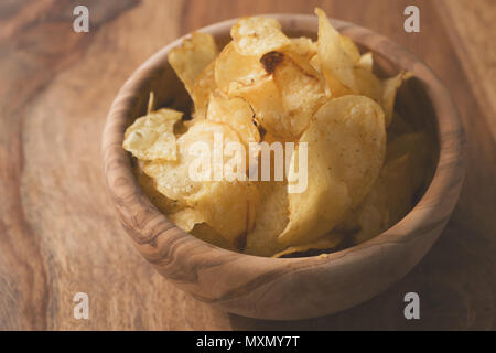 Bio Kartoffelchips mit Kräutern in Schüssel auf Holz Tisch Stockfoto