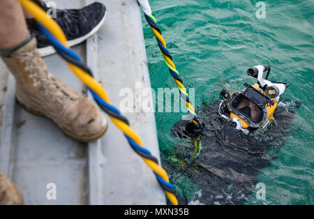 Ein U.S. Army engineer Taucher mit der 511 . Ingenieur Dive Loslösung von Fort Eustis, Virginia, wartet auf die Genehmigung zum Tauchen unter der Oberfläche des Arabischen Golfs, vor der Küste von Kuwait Naval Base, Unterwasser zu leiten - tauchen Aufgaben Nov. 18, 2016. Die zwei Woche Training, Betrieb Deep Blue, erforderliche Armee Taucher tauchen Aufgaben wie Schneiden Material unter Wasser mit einer Kettensäge und eine Fackel. (U.S. Armee Foto von Sgt. Angela Lorden) Stockfoto