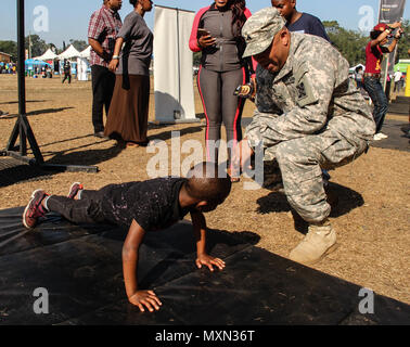 Armee Sgt. Marcus T. Williams, chemische Spezialist, 143d Sustainment Command (Auslandseinsätze), ruft ein Junge eine weitere Wiederholung während pushup Herausforderung durchgeführt 19.11.2016, an der GoArmy.com interaktive sowohl auf dem Messegelände liegt ausserhalb des Lagers Welt Stadion in Orlando, Fla. Williams, ein Eingeborener von Orlando, Eintritt in den aktiven Dienst und Soldaten, sich Zehntausende Fans an der Florida Klassiker, einer der größten Fußball-rivalitäten der Nation zwischen zwei historisch schwarze Hochschulen. Die Truppen verwaltet mehrere interaktive Herausforderungen, die Stärke der Lüfter getestet Stockfoto