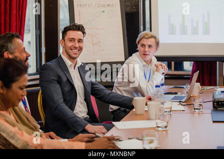Business Männer im Gespräch mit den anderen Teilnehmern der Konferenz während der Präsentation. Stockfoto