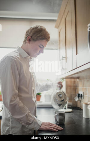 Junge männliche Erwachsene eine Tasse Tee. In regelmäßigen Tasse Tee vor der Arbeit. Stockfoto
