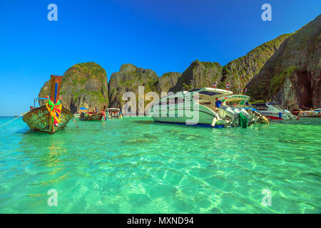 Maya Bay, Phi Phi Leh, Thailand - 31. Dezember 2015: Longtail Boot und große Motorboot parken in der Maya Bay Lagune. Massentourismus hat beschädigte und verschmutzte die himmlische Insel Ko Phi Phi Leh. Stockfoto