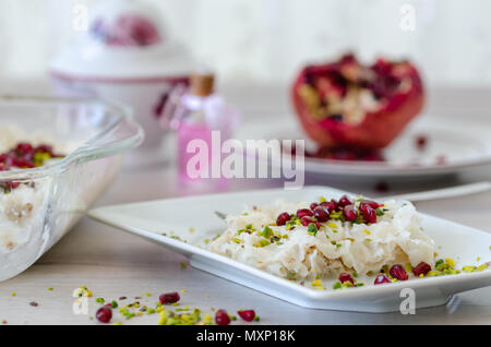 Traditionelle Ramadan Dessert Gullac auf dem Tisch. Es ist mit gullac, Milch, Rosenwasser, Nussbaum, Vanille. Es ist mit Granatapfel und Piste eingerichtet Stockfoto