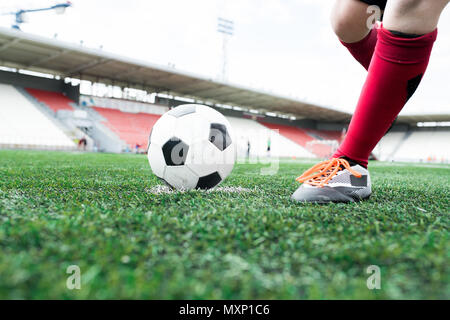 Nicht erkennbare Junge Kicking Kugel Stockfoto