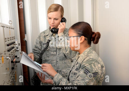 Von links Staff Sgt. Caitlin Gillaspie und Senior Airman Erika Santos, 5 Bombe Befehl Flügel post Notfallmaßnahmen, die Offiziere, verwenden Sie ein Secure Radio am Minot Air Force Base, N.D., Nov. 16, 2016. Die Minot Post-Befehl der Befehl und Kontrolle Link zwischen dem höchsten Führer unserer Nation, wie Präsident, Sekretär für Verteidigung, Air Force Global Strike Command und Führungskräfte unsere Flügel". (U.S. Air Force Foto/Flieger 1. Klasse Jessica Weissman) Stockfoto