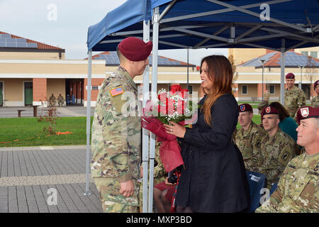 Frau ausgehender Befehl Sgt. Maj. Travis C. Crow erhält einen Strauß roter Rosen von SPC. Joshua Kanada, während der Übergang der Verantwortung Zeremonie für 54th Brigade Ingenieur Bataillon an Caserma Del Din in Vicenza, Italien, November 23, 2016. Die 173Rd Airborne Brigade in Vicenza, Italien, ist die Armee Contingency Response Force in Europa, und ist in der Lage, Kräfte projizieren die vollständige Palette von militärischen Operationen über den Vereinigten Staat in Europa, Zentral- und Südafrika Befehle Verantwortungsbereiche zu führen. (U.S. Armee Foto von Antonio Bedin) Stockfoto