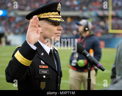 Brig. Gen. Patrick Frank, der 1.Infanteriedivision und Fort Riley, Senior Commander, hebt seine rechte Hand in Service Mitglieder, die wählten, während Halbzeit auf der Chicago Bears alute Service" Spiel, Nov. 27 an Soldier Field, in Chicago zu reenlist zu schwören. Fast 100 Mitarbeiter aus allen Leistungen der Heranführungs- Spiel und halftime show bedeutete das Opfer aller Service Mitglieder zu ehren. (U.S. Army National Guard Foto von 1 Lt Aaron Ritter, Illinois National Guard Public Affairs) Stockfoto