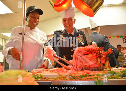 SCHOFIELD Kasernen, Hawaii - Command Sgt. Maj. Teresa Duncan, Senior Advisor angeworben, 14th Military Police Brigade, 8 Theater Sustainment Command, erhält Carving Tipps von Staff Sgt. Tawana Roberts, kulinarische Spezialisten, 524Th bekämpfen Sustainment Unterstützung Bataillon, 25 Sustainment Brigade, 25 Infanterie Division, während des Thanksgiving Feier Mahlzeit bewirtet durch die 25 Erhaltung Bistro Speisesaal 07.11.23, hier. (U.S. Armee Foto: Staff Sgt. Taresha Hill, 14th Military Police Brigade Public Affairs, 8 Theater Sustainment Command) Stockfoto