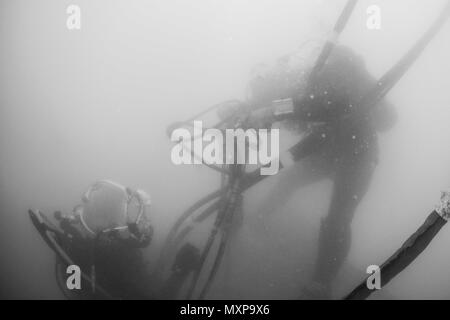 Petty Officer 1st Class Matt Ramirez, rechts, Unterwasser Bau Team (UCT) 2 und Petty Officer 2. Klasse Casey Campbell, auf USS Emory S. Land zugewiesen (39), on Nov. 14, 2016 zugeordnet. CDDB ist die Präzision unter Wasser Abriss und Bergung Sprühbehinderungen von Diego Garcia ist tief Entwurf Wharf zu entfernen. CDDB ist auf der dritten Haltestelle Ihrer Bereitstellung, in dem Sie die Inspektion, Wartung und Reparatur der verschiedenen Unterwasser- und Waterfront Einrichtungen während unter Commander, Task Force (CTF) 75, die primäre Expeditionary task force verantwortlich für die Planung und Executio Stockfoto