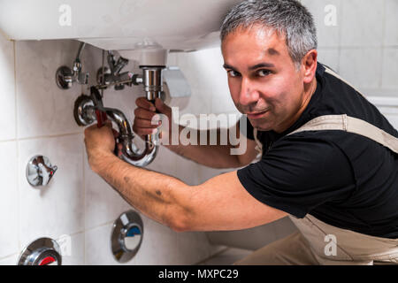 Spezialist männlichen Klempner Reparaturen Wasserhahn im Badezimmer Stockfoto