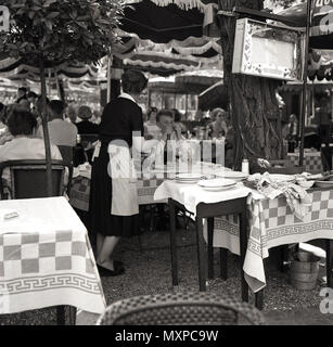 1950s, historisch, eine Kellnerin, die Gäste vor einem Restaurant in Paris, Frankreich, bedient. Stockfoto