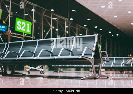 Leere Sitze Bank im Flughafen Halle in der Nähe von flugsteig am internationalen Flughafen. Warten auf Boarding bei Nacht Stockfoto