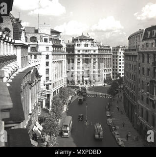 1950er, historische Ansicht von oben auf dem Aldwych, Westminster, London, England, Großbritannien, zeigt Gebäude, Straße und Transport. Eine Einbahnstraße im Zentrum Londons, bekannt für seine Hotels, Restaurants und zwei Theater, ist halbrund im Design. Links die Spitze des Aldwych Theaters, das im Dezember 1905 eröffnet wurde. Stockfoto