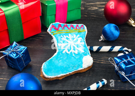 Hausgemachte Lebkuchen Socke mit Weihnachtsschmuck auf hölzernen Hintergrund Stockfoto