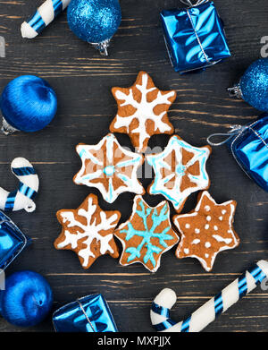 Hausgemachte Weihnachten Lebkuchen cookies Schneeflocken in Form von Fichte mit Dekorationen auf Holz- Hintergrund Stockfoto