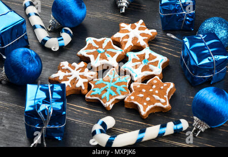 Hausgemachte Weihnachten Lebkuchen cookies Schneeflocken in Form von Fichte mit Dekorationen auf Holz- Hintergrund Stockfoto