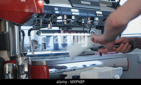 Barista mit Kaffeemaschine bereitet frischen Kaffee Stockfoto