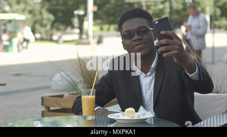 Happy afrikanisch-amerikanischen Geschäftsmann unter selfie im Cafe Stockfoto