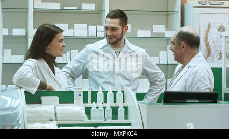 Team der Apotheker, Chemiker, Frau und Mann in der Apotheke Drogerie und sprechen positiv Stockfoto