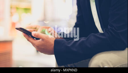 Asiatische Geschäftsmann mit Mobiltelefon für Decke und Textnachrichten auf Ihr Mobiltelefon Stockfoto