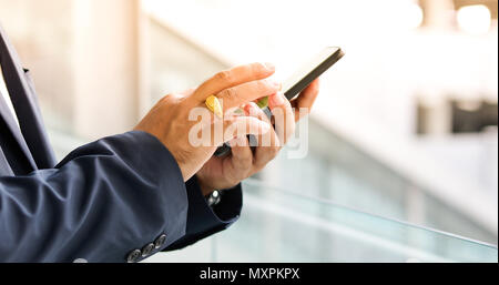 Asiatische Geschäftsmann mit Mobiltelefon für Decke und Textnachrichten auf Ihr Mobiltelefon Stockfoto