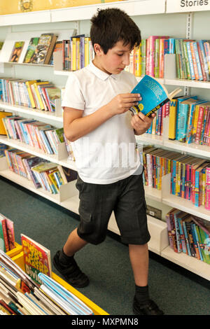 Großbritannien, Surrey, Großbritannien - 10 Jahre Schüler wählen Bücher in öffentlichen Bibliothek