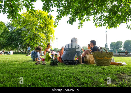 Freunde genießen das gute Wetter und ein Picknick im Park an der Gemeinde Gärten in Hammersmith in London, Großbritannien, haben Stockfoto