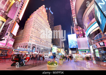 NEW YORK, USA - 12. April: Die Architektur der berühmten Times Square in New York City, USA mit seinen leuchtreklamen und Panels in der Nacht und eine Menge tour Stockfoto