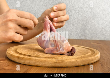 Hände von Frau Wachtel vorbereiten für das Kochen auf Holz Schneidebrett Stockfoto