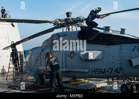 161120-N-EO 381-072 arabischen Golf (Nov. 20, 2016) Segler zum Sumpf Füchse von Hubschrauber Maritime Strike Squadron (HSM) 74 Waschen einen MH-60R Sea Hawk Hubschrauber an Bord der geführte Anti-raketen-Zerstörer USS Nitze (DDG94) während einer Süßwasser abwaschbares zugeordnet. Nitze, eingesetzt als Teil der Eisenhower Carrier Strike Group, unterstützt Maritime Security Operations und Theater Sicherheit Zusammenarbeit in den USA 5 Flotte Bereich der Operationen. (U.S. Marine Foto von Petty Officer 3. Klasse Casey J.Hopkins) Stockfoto