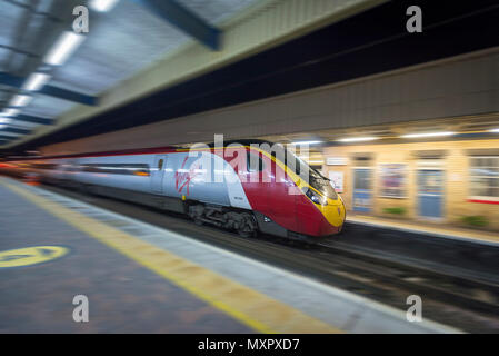 Jungfrau pendolino Zug mit Geschwindigkeit durch eine Station in der Nacht. Stockfoto
