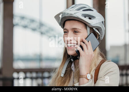Seitenansicht eines lächelnden Geschäftsfrau einen Anruf beim Radfahren zu arbeiten. Stockfoto