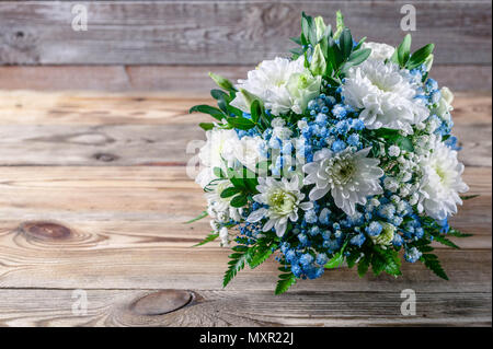 Brautstrauß aus weißen und blauen Chrysanthemen auf einer hölzernen Hintergrund Stockfoto