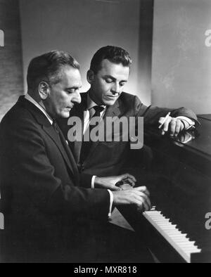 Alan Jay Lerner (mit Zigarette) und Frederick Loewe arbeiten zusammen am Klavier auf einem anderen Broadway Musical Score. Die beiden arbeiteten auf die Broadway Produktion "My Fair Lady." New York, New York, 1960. Stockfoto