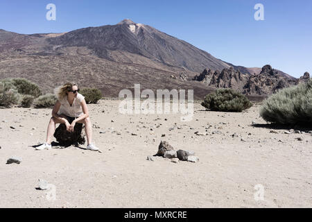 Frau Standortwahl auf einem Felsen mit einem Vulkan im Hintergrund Stockfoto