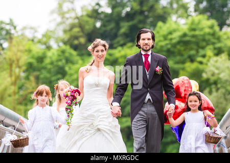 Hochzeit paar mit Blume Kinder auf Brücke Stockfoto