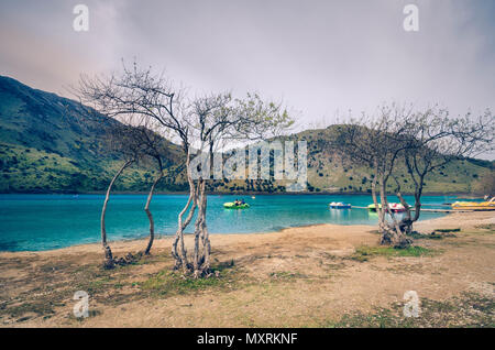 Touristen auf dem Wasser Rad Segeln entlang der tropischen See von Kournas bewundern Sie die typische kretische Landschaft. Stockfoto