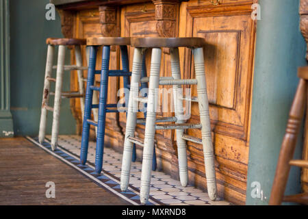 Bemalten hölzernen Barhockern vor einer Bar aus Holz Stockfoto