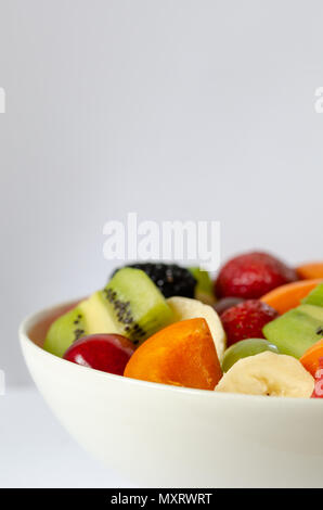 Frischen bunten Obstsalat auf weißem Hintergrund. Gesunde Ernährung, Diät Konzept. Stockfoto