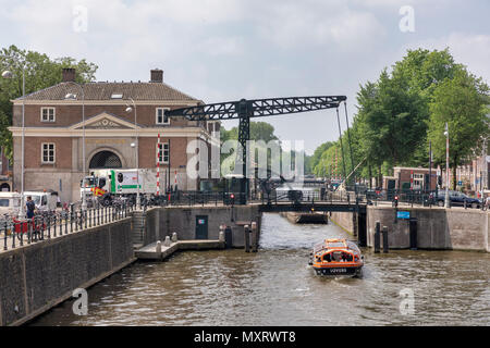 AMSTERDAM, NIEDERLANDE - 30. Mai: ein Schiff geht unter einer beweglichen Brücke von Nieuwe Herengracht am 30. Mai 2018 in Amsterdam, Niederlande. In Amsterdam finden Sie 1.753 Brücken, von denen viele offen zu lassen Schiffe übergeben werden. Stockfoto