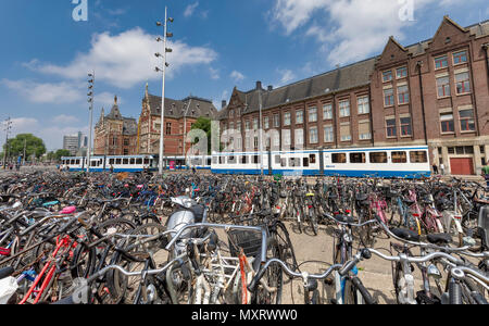 AMSTERDAM, NIEDERLANDE - 30. Mai: Hunderte von Fahrräder Parken vor dem Bahnhof (auf Niederländisch: Amsterdam Centraal) am 30. Mai 2018 in Amsterdam, Niederlande. Dies ist der wichtigste Punkt der Kreuzung in der Stadt. Stockfoto