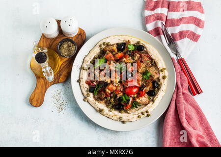 Vegan panzanella Salat auf einer Schicht von Hummus auf einem Teller. Leckeres und gesundes Essen. Stockfoto