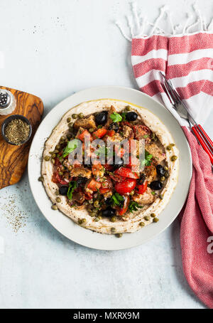 Vegan panzanella Salat auf einer Schicht von Hummus auf einem Teller. Leckeres und gesundes Essen. Stockfoto