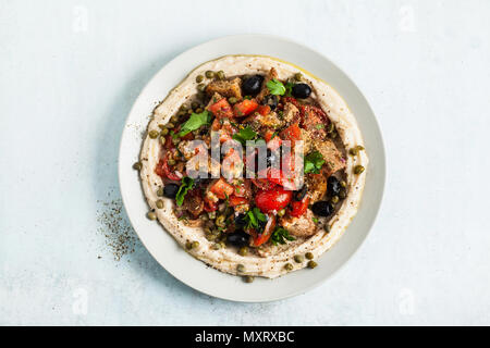 Vegan panzanella Salat auf einer Schicht von Hummus auf einem Teller. Leckeres und gesundes Essen. Stockfoto