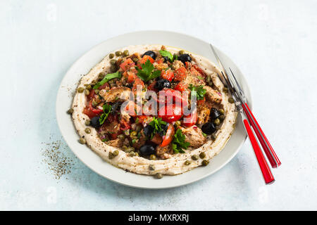 Vegan panzanella Salat auf einer Schicht von Hummus auf einem Teller. Leckeres und gesundes Essen. Stockfoto