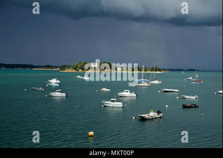 Vannes (Bretagne, Frankreich): Segel- und Motorboote vor Anker in der Logeo Marina liegen, unter einem stürmischen Himmel gesehen. Stockfoto