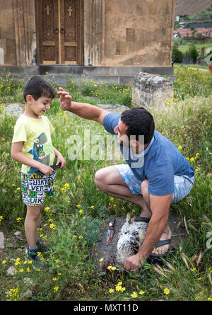 Areni, Armenien, 1. Juni, 2018: der Mensch ist ein Kopf von einem Hahn als Opfer an Gott Stockfoto