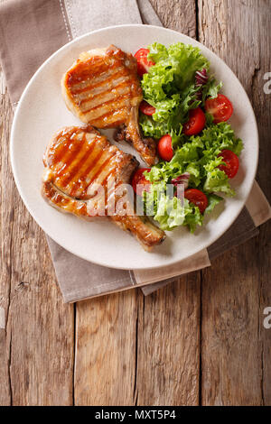 Glasierte gegrilltes Steak mit frischen Salat Gemüse und Blätter in der Nähe auf einem Teller. Vertikal oben Ansicht von oben Stockfoto