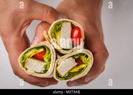 Gegrillte burrito Wraps mit Hähnchen und Gemüse (Fajitas, Fladenbrot, shawarma) in den Händen Stockfoto