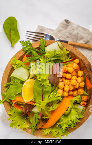 Sommer Gemüse Salat mit Kichererbsen in eine hölzerne Schüssel. Gesunde vegane Ernährung Konzept. Stockfoto